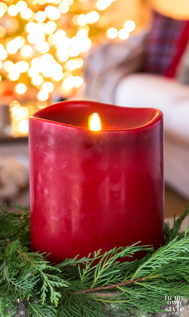 Large red Christmas candle in a cedar wreath.