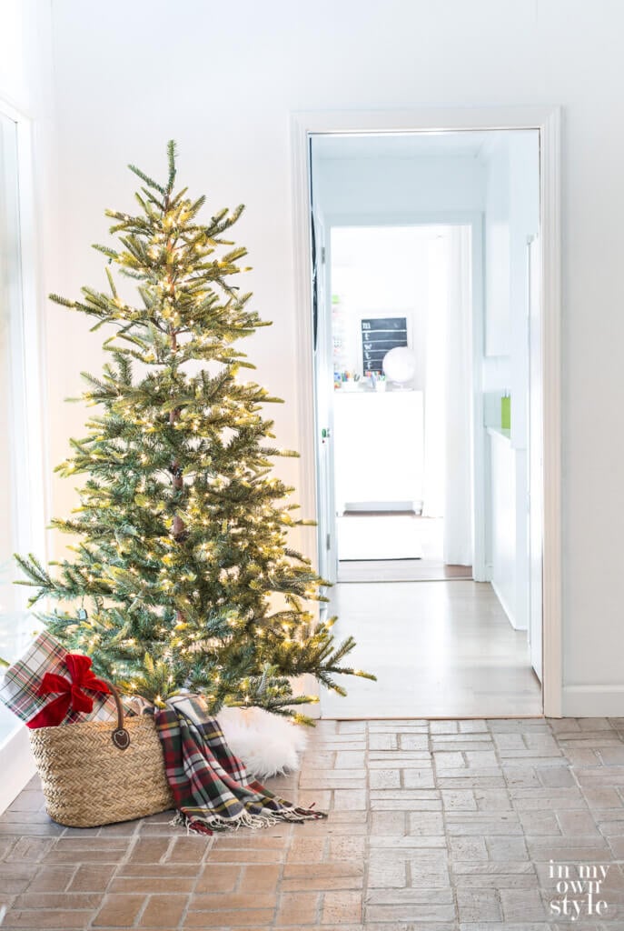 Christmas tree with white twinkle lights in foyer.