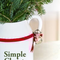 Simple Christmas Decorating Ideas. White pitcher with red ribbon and jingle bells tied on.