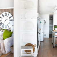 New plate rack wall between kitchen and living room Text overlay says Easy Built-In Plate Rack Wall