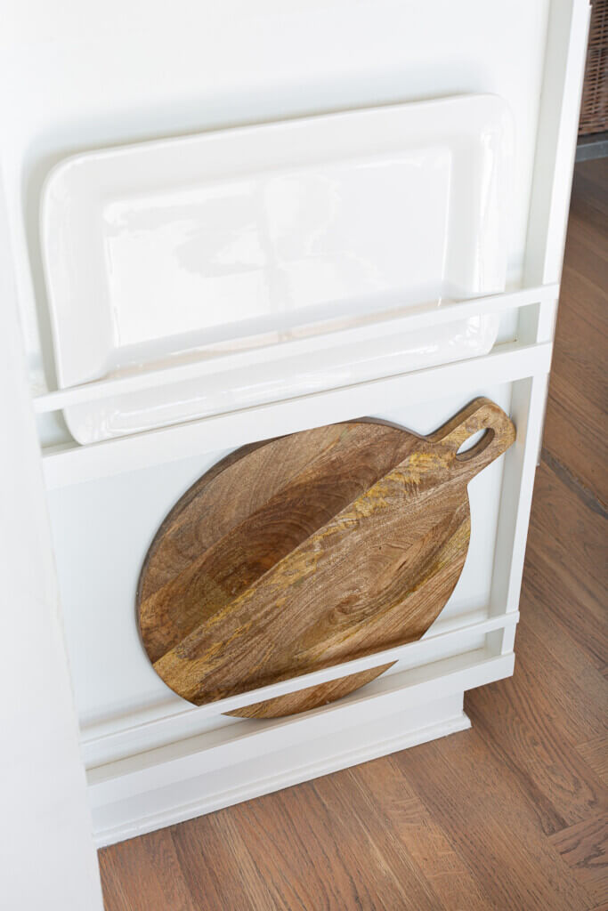 Round wood cutting board on bottom shelf.