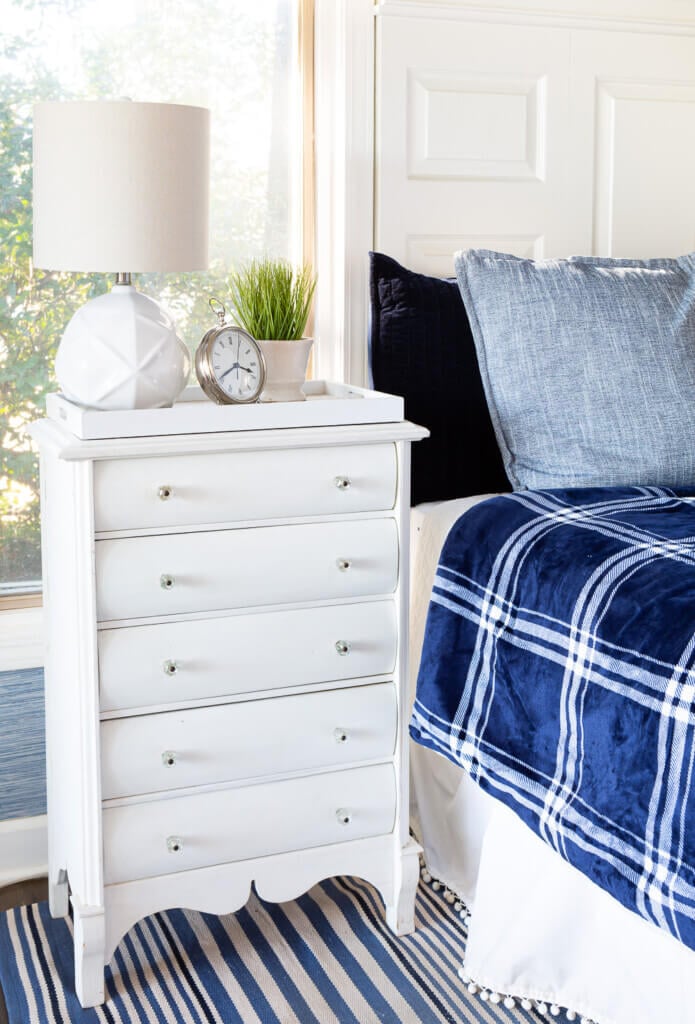 white night table with drawers in blue and white bedroom