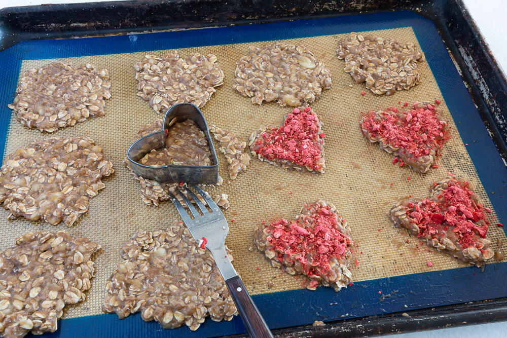 Heart cutout cookies on baking sheet ready for oven.