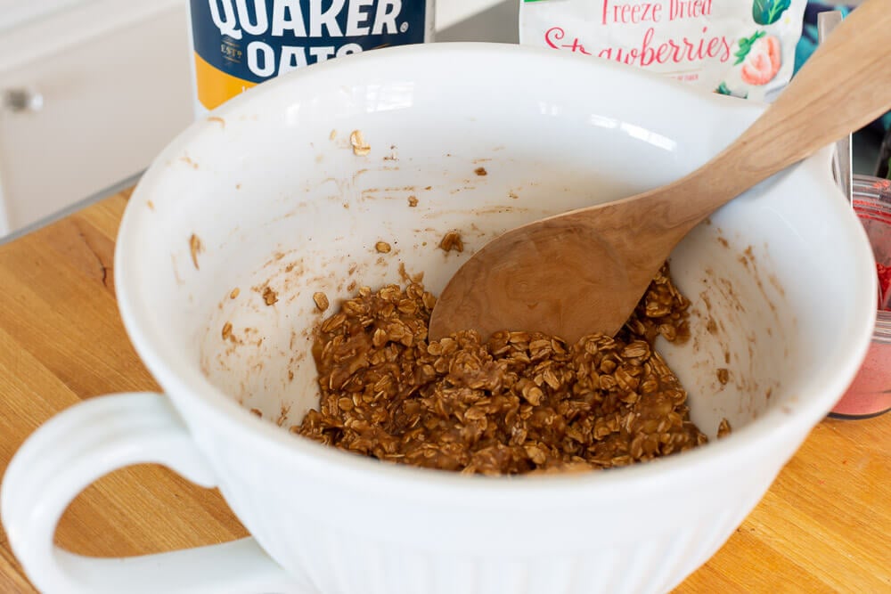 3 ingredient banana oatmeal cookie batter being stirred in a bowl.