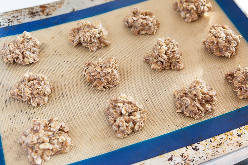 Spoonfuls of banana oatmeal cookie batter on baking sheet.