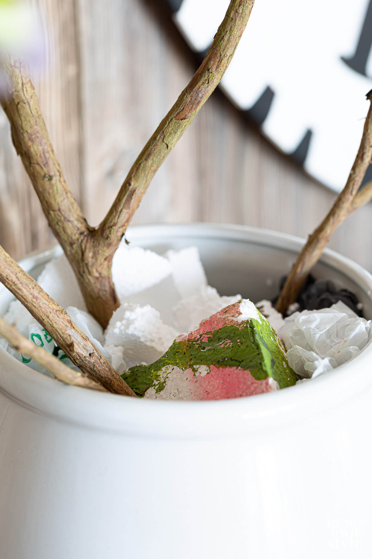 Styrofoam stuffed in planter to hold branches in place.