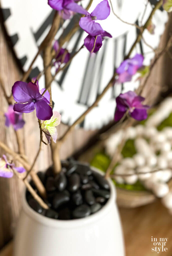 Looking across a console table decorated for spring with faux forced flowering branches.