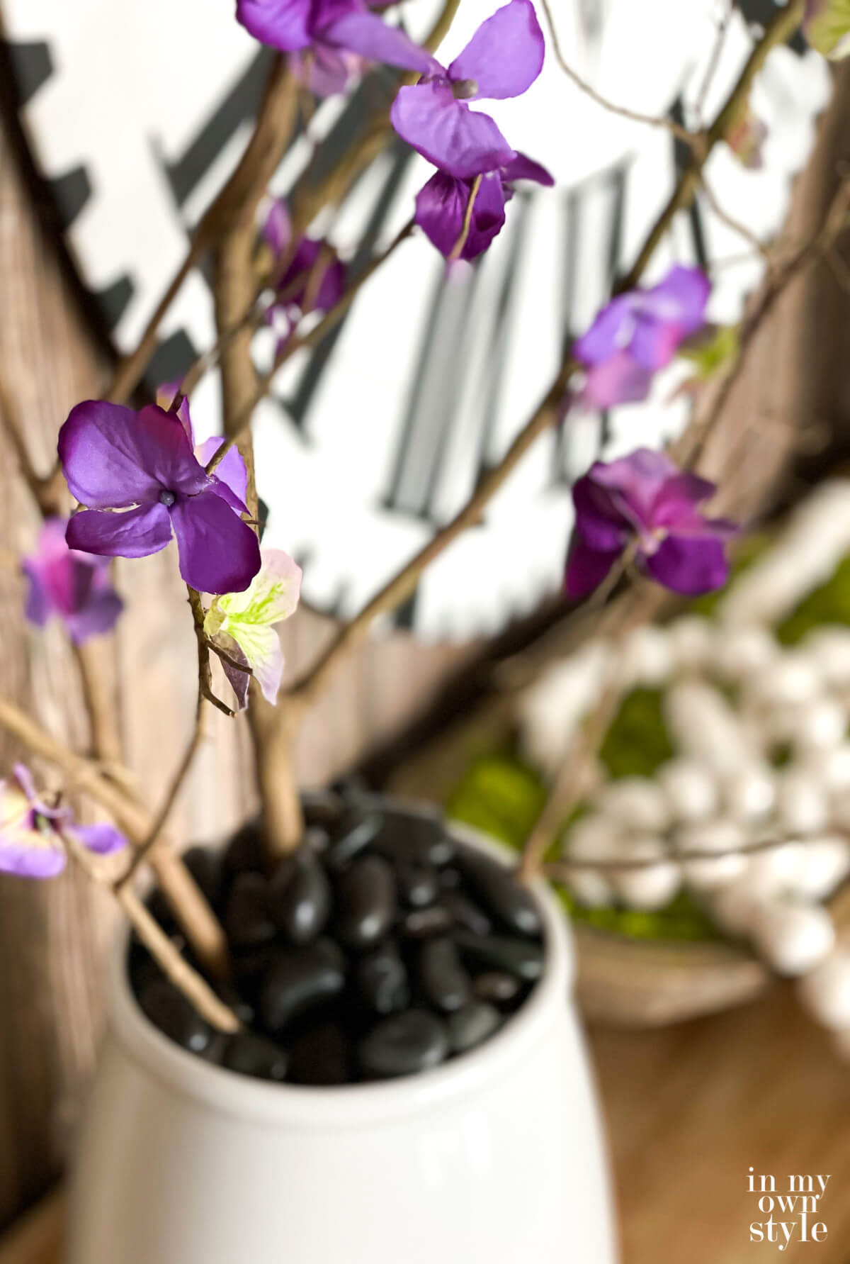Looking across a console table decorated for spring with faux forced flowering branches.