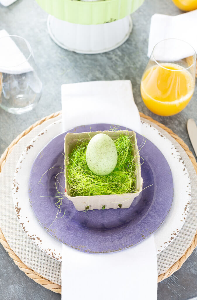 Easter brunch table setting using white and purple dinner plates.