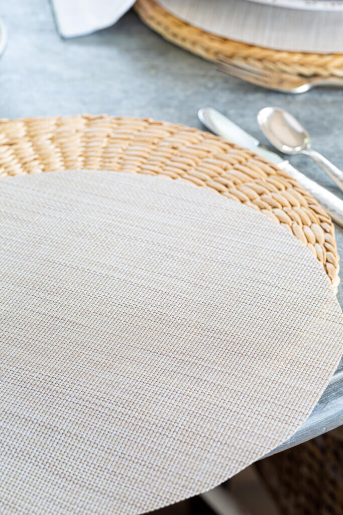 Two woven round placemats layered.