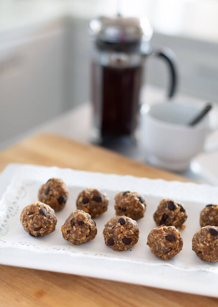 Protein no bake energy balls on a white tray. French coffee press in the background.