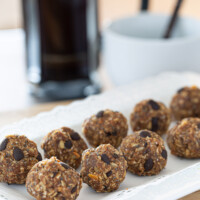 Two rows of healthy energy power balls on white plate.