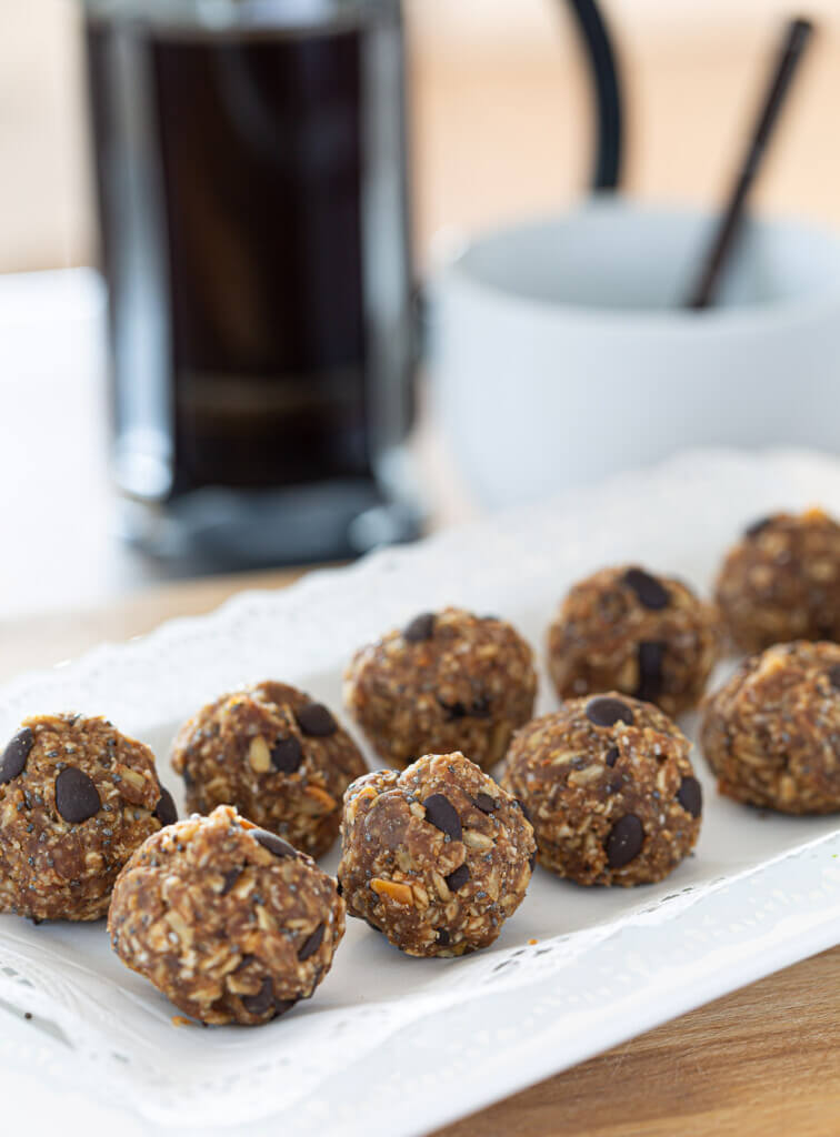 Two rows of healthy no bake energy  balls on white plate.