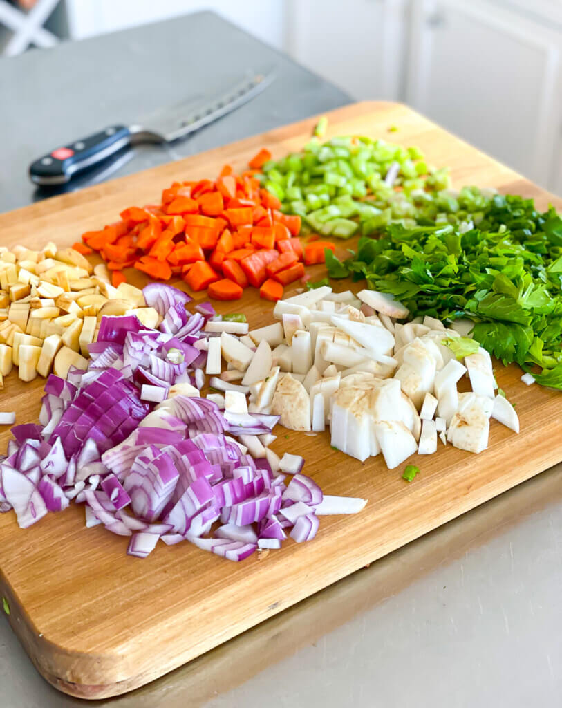 cut up veggies on a wood cutting board.