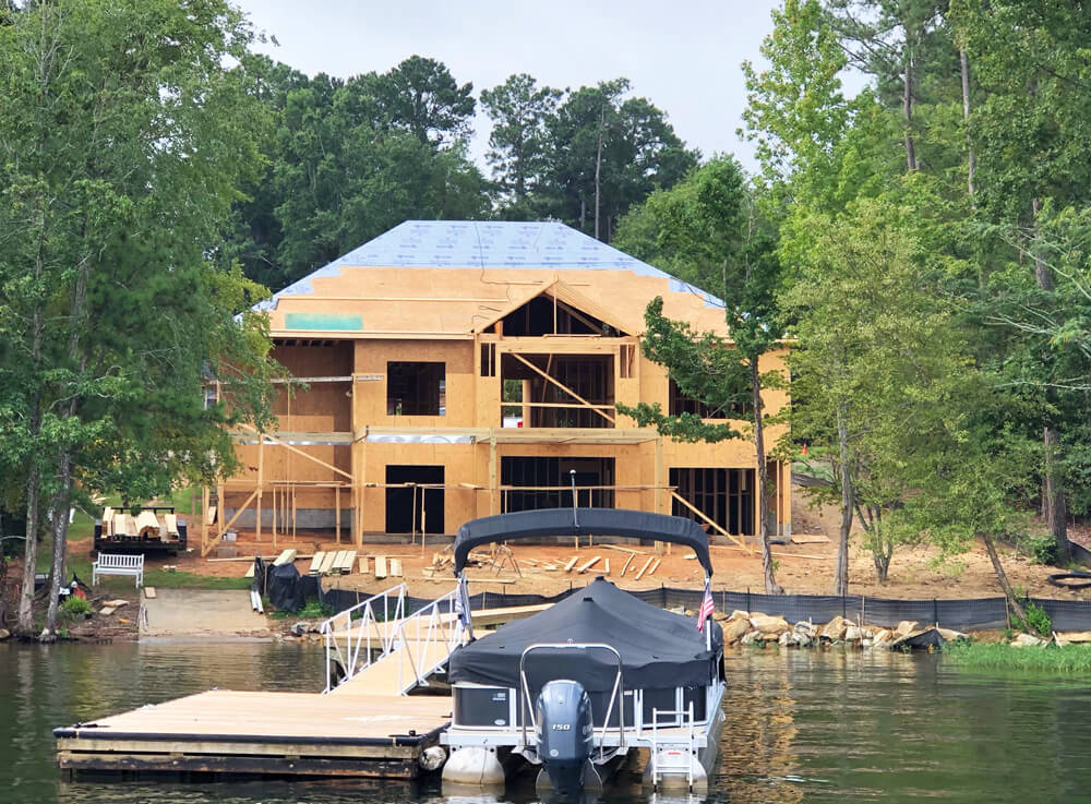 House being built along the shores of a lake.