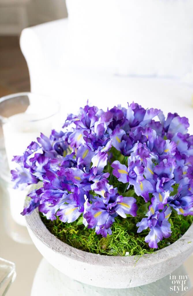 Pretty purple flowers in large bowl on coffee table.