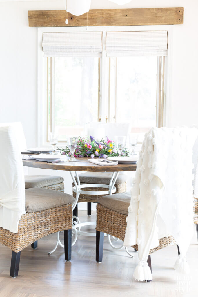 DIY round wood table attached to a white metal base. Chairs around the table.