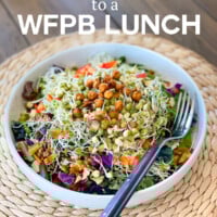Salad bowl filled with chopped veggies and sprouts.
