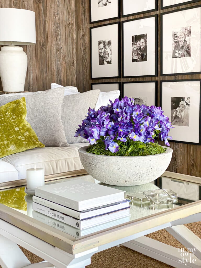 Modern low sided concrete bowl planter filled with purple flowers on living room table.