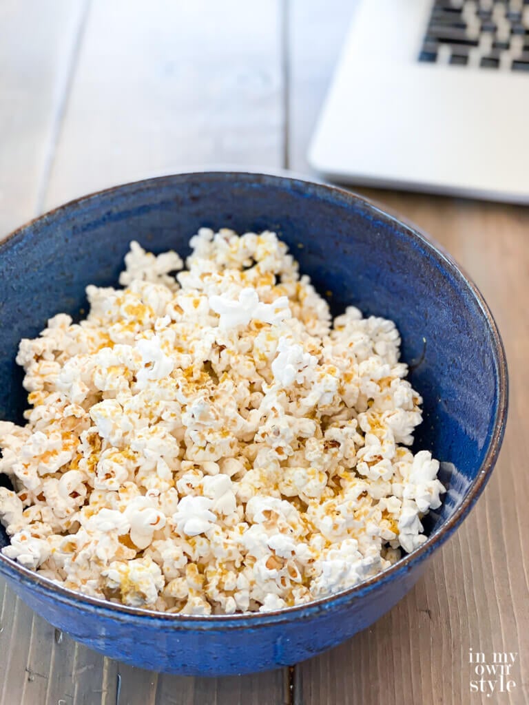Bowl of No Oil Air popped popcorn with plant based seasoning on it.