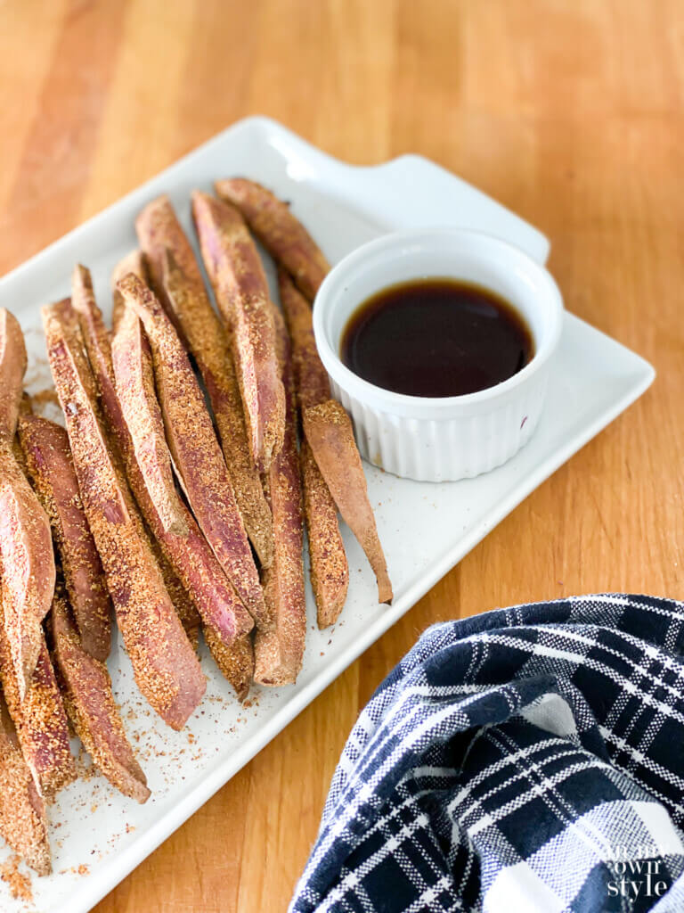 Baked Purple sweet potato fries on a serving plate with dipping sauce.