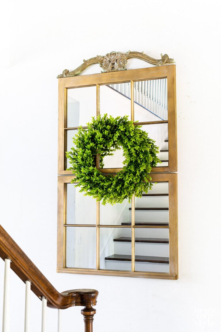 Two old wood window frames placed on wall to make a decorative mirror.