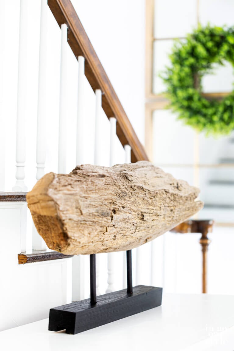 piece of found driftwood made into modern art when placed on a stand.