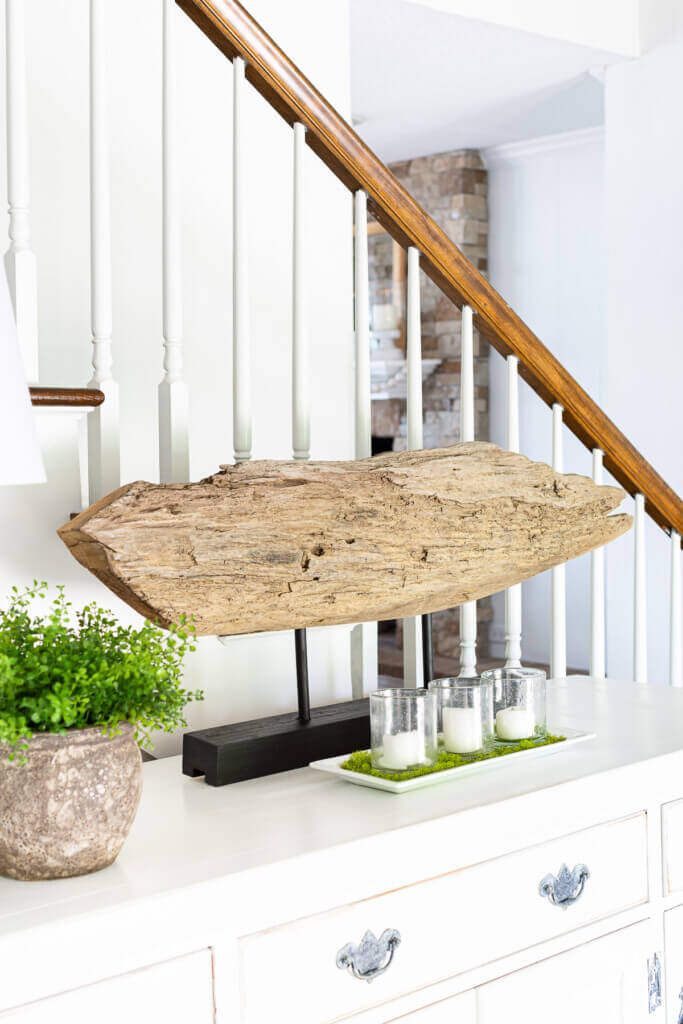 driftwood sculpture on stand on a foyer sideboard