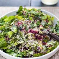 Close up of a low sided white salad plate filled with beet and leek salad.