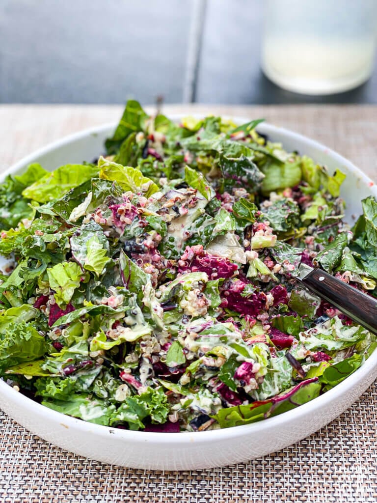 Close up of a low sided white salad plate filled with beet and leek salad.