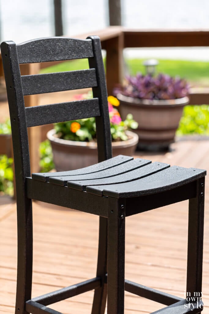 Close up of a POLYWOOD La Casa Cafe Farmhouse Trestle Bar Set chair. in the color black.