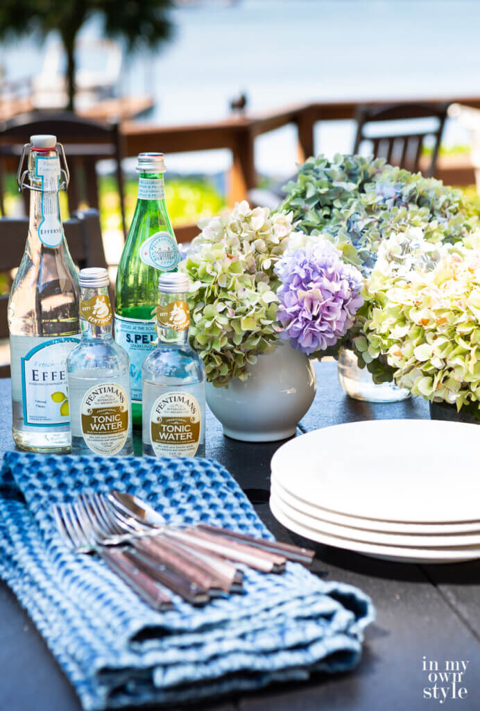 POLYWOOD Outdoor table set up for entertaining with drinks, plates and flowers.