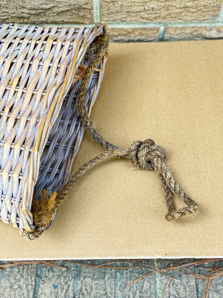 A rope hanger on flat sided basket used for a door.