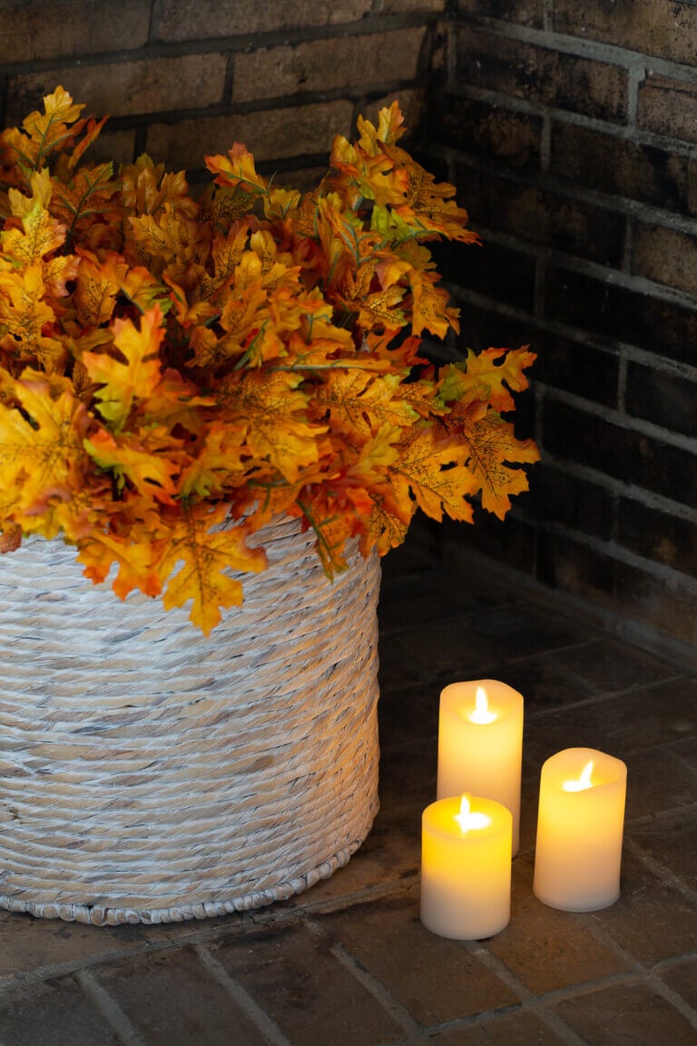 Cozy home interiors - basket in a fireplace filled with maple leaves.