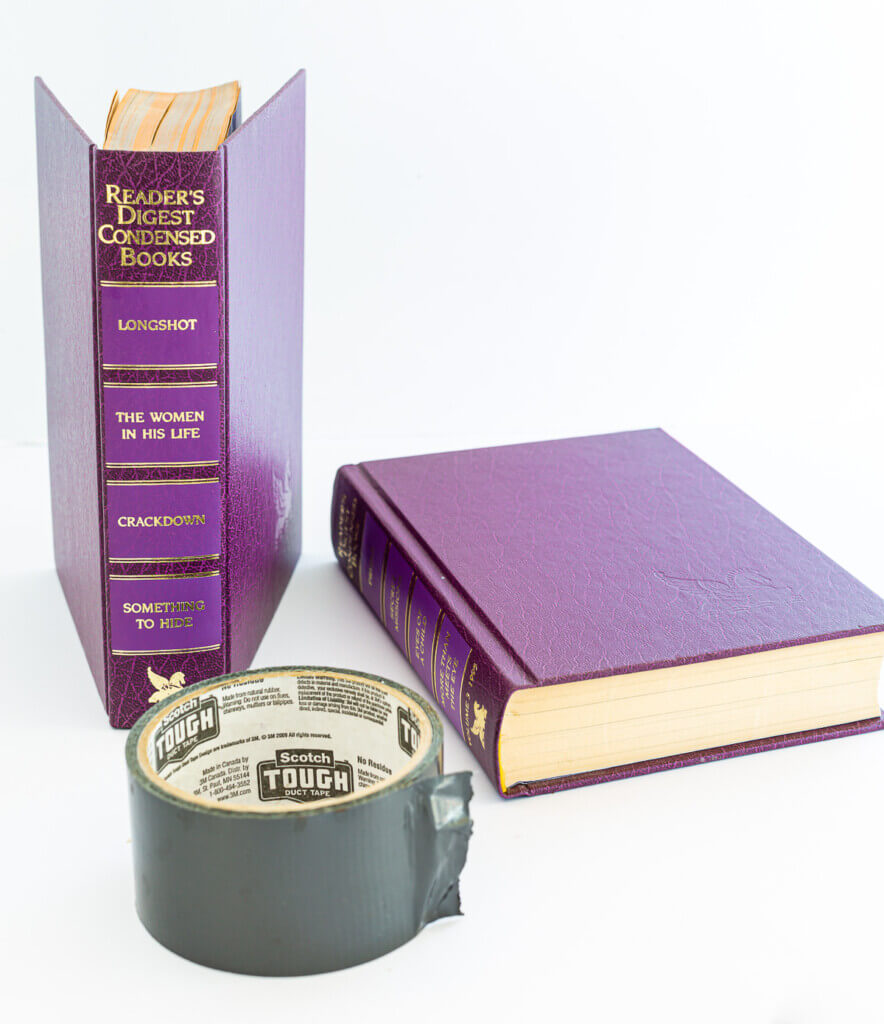 Supplies needed to make a planter or vase cover with two old books.