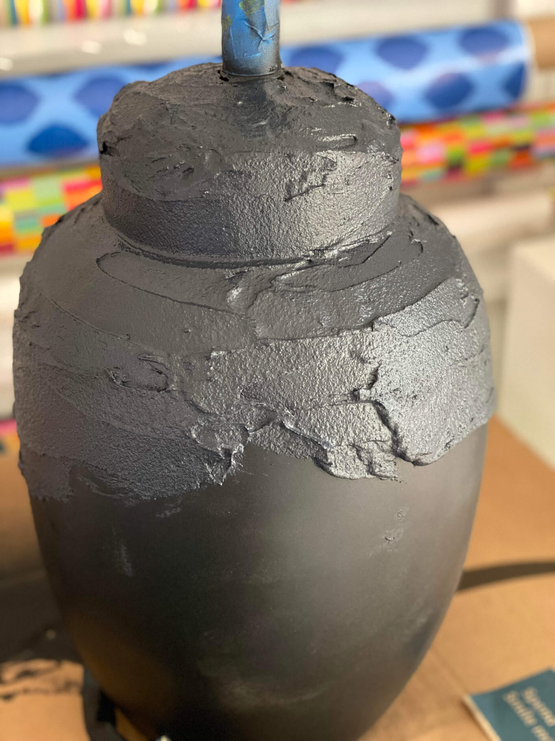 Textured paint being added to a table lamp base.