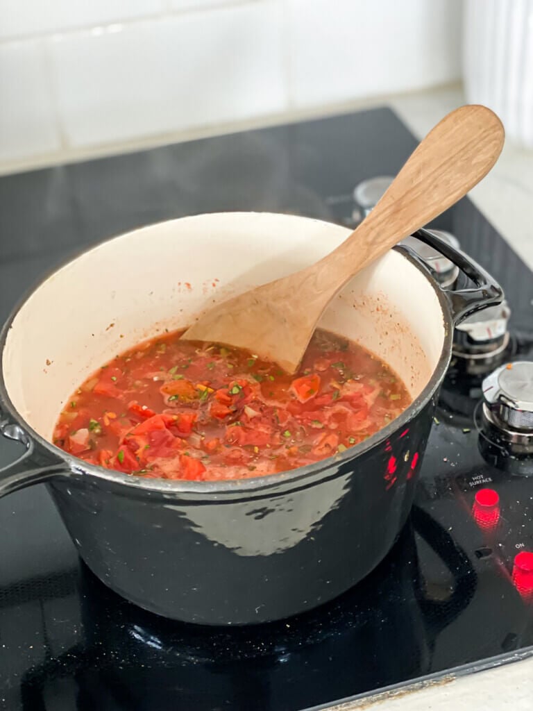 Fire roasted vegan tomato soup being cooked on a stove.