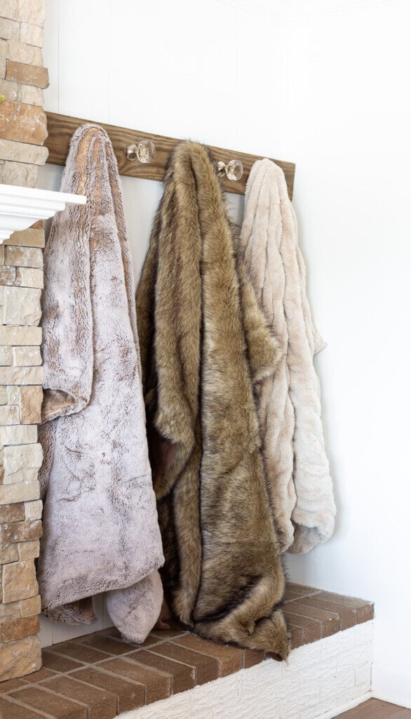Living room blanket storage idea - use doorknobs on a Shaker style peg wall rack.