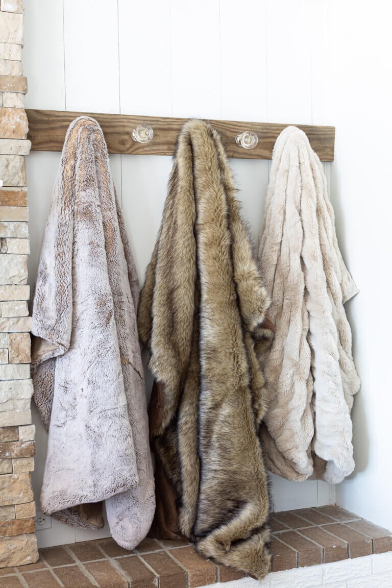 3 fur throws on Blanket Holder for living room wall.