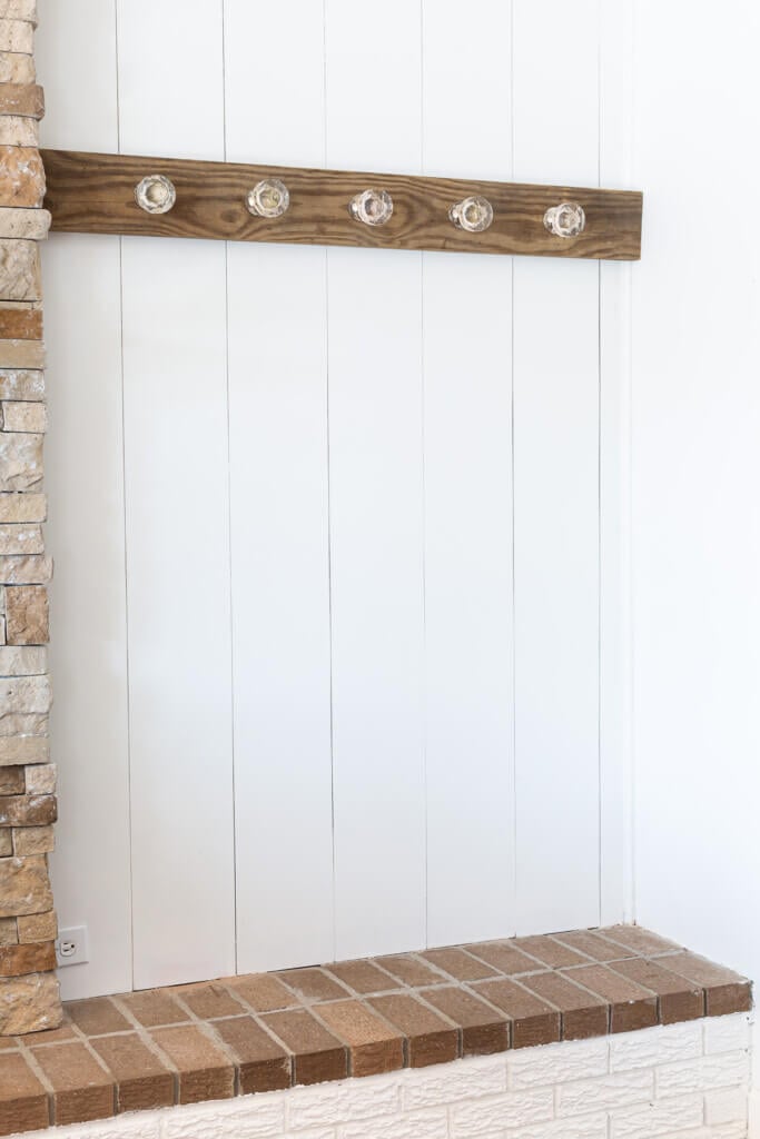 Blanket display idea made by mounting a board on a wall and attaching glass door knobs to decoratively hang blankets and quilts.