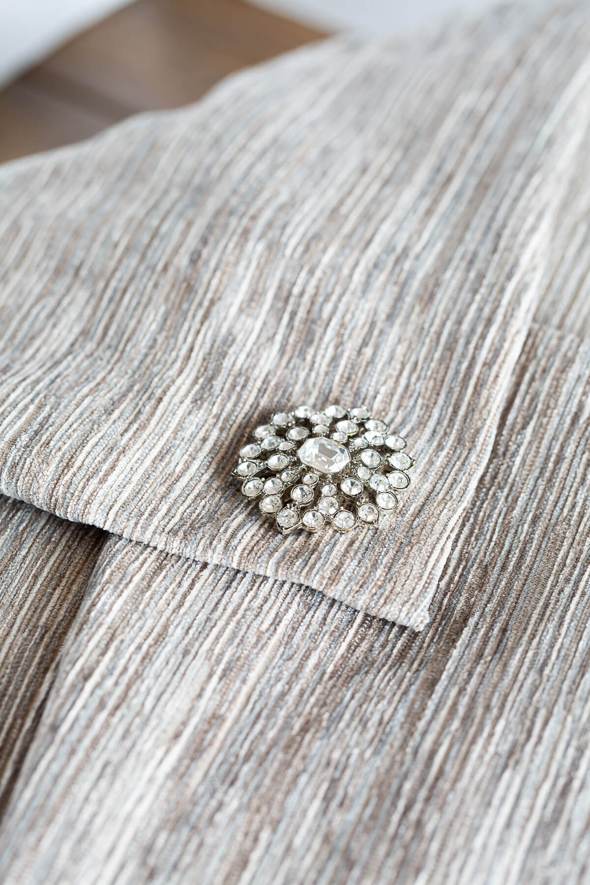 close up of a no zipper pillow cover to make with a pretty pin embellishment.