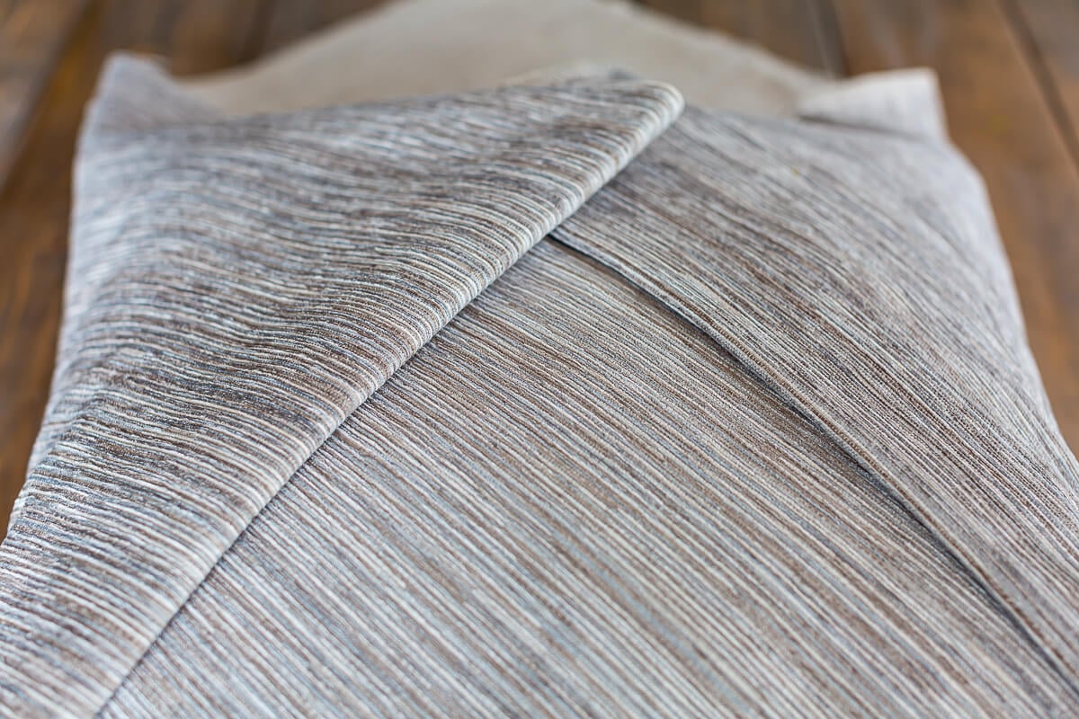 Folded edges of fabric on no sew envelope pillow.
