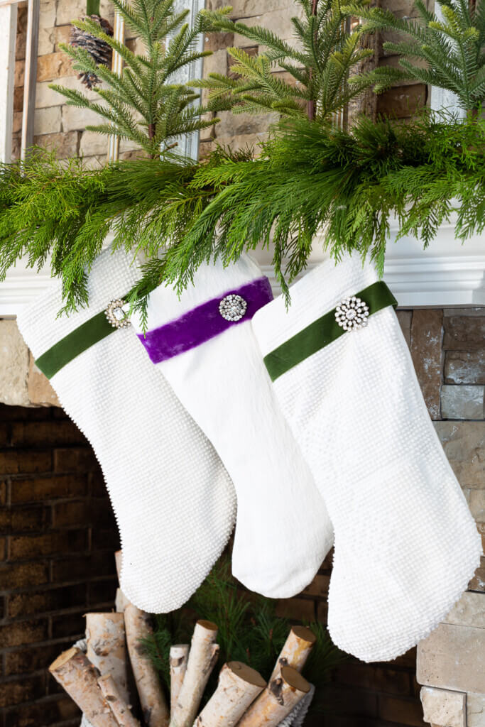 3 white Christmas stockings hanging on mantel.