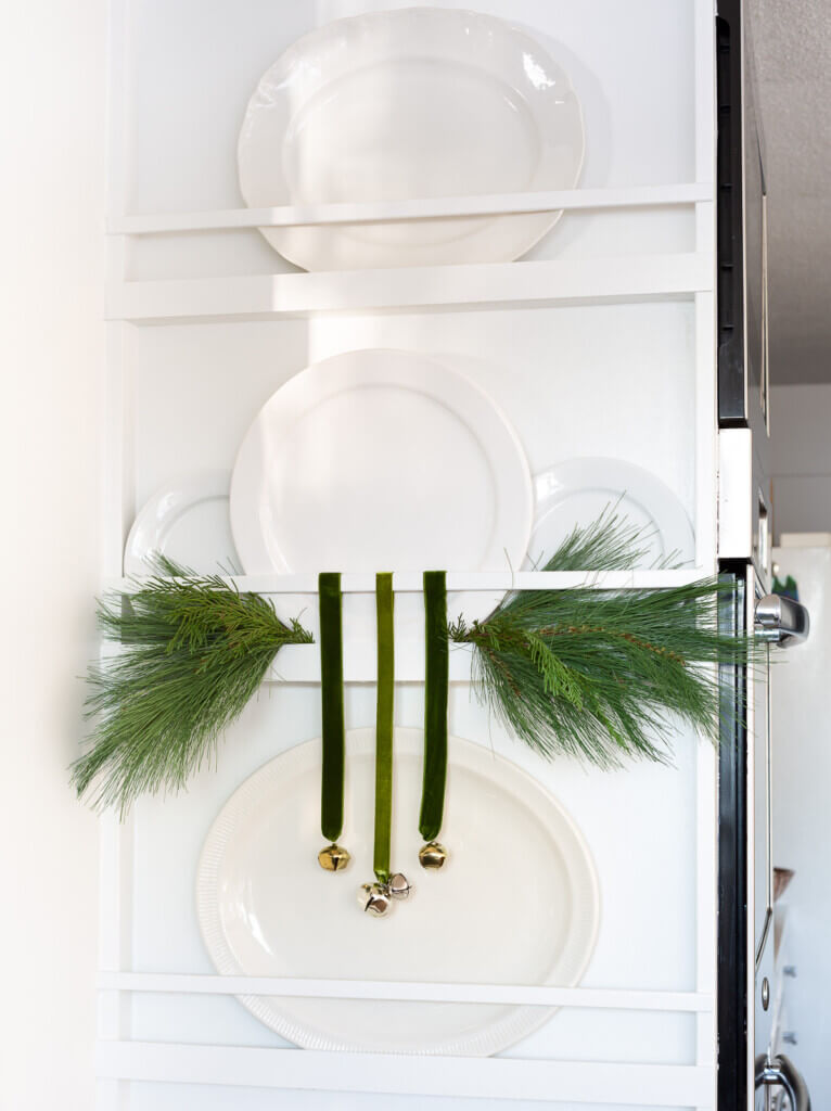 Plate rack wall with sprigs of pine and jingle bells