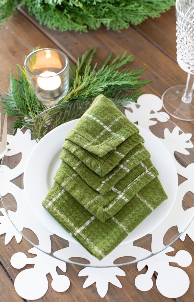 Green napkin folded in the shape of a Christmas tree