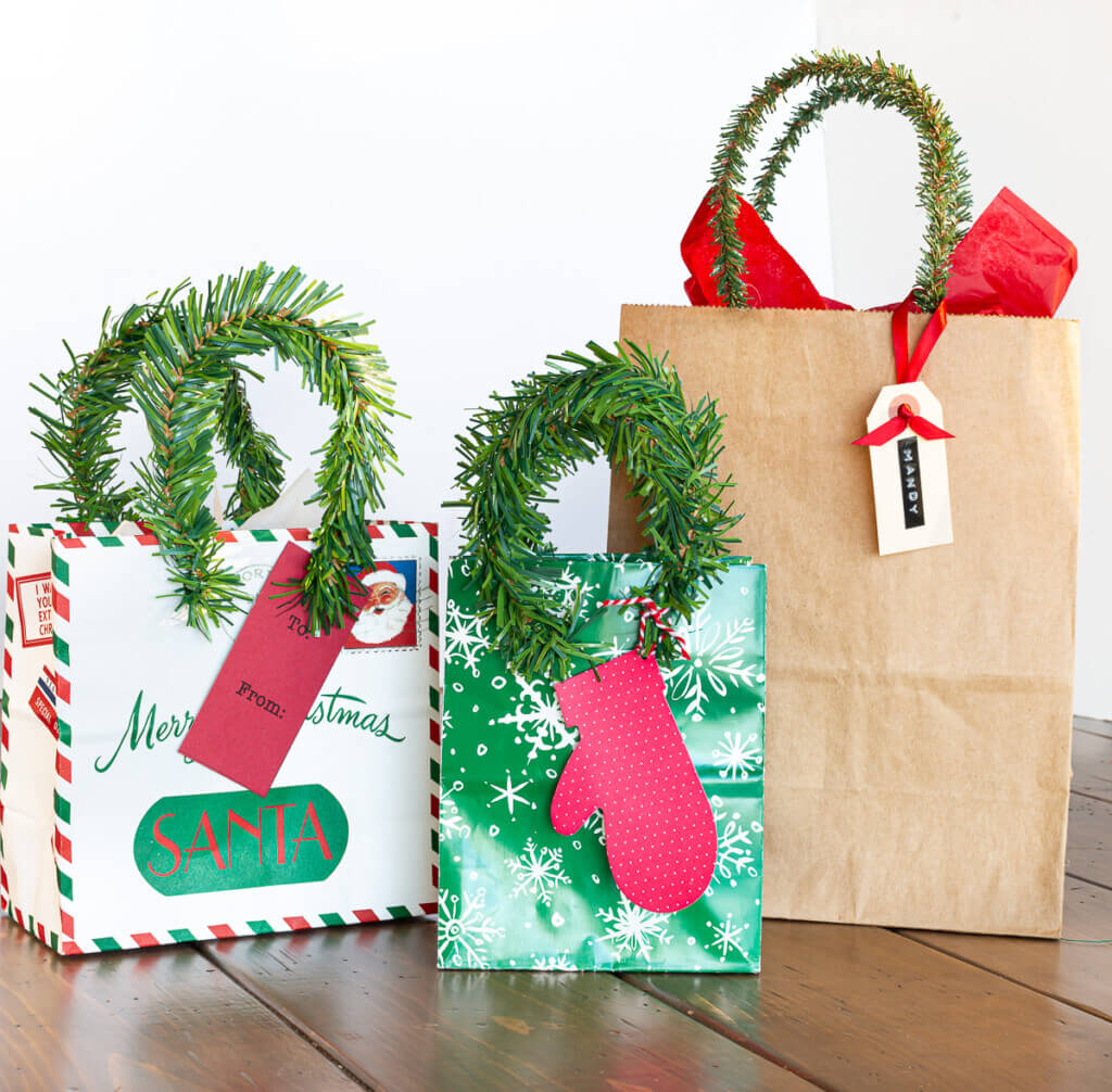3 Christmas gift bags with new handles made using pine garland ties.
