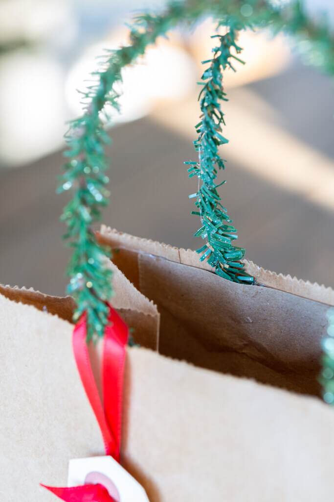Where to attach a pine garland tie to a gift bag to make a handle for the bag.