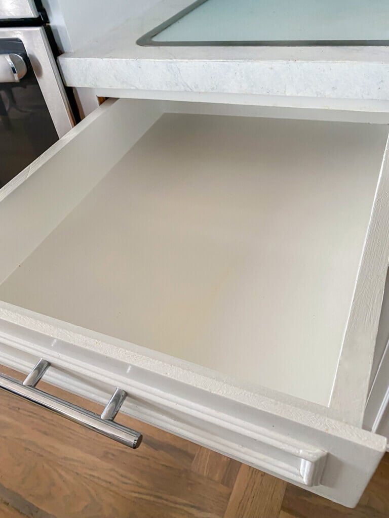 Empty drawer ready to be organized with new spice jars and labels.