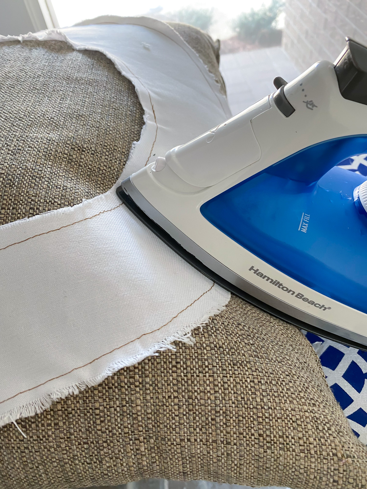 Ironing on a letter applique onto a pillow.