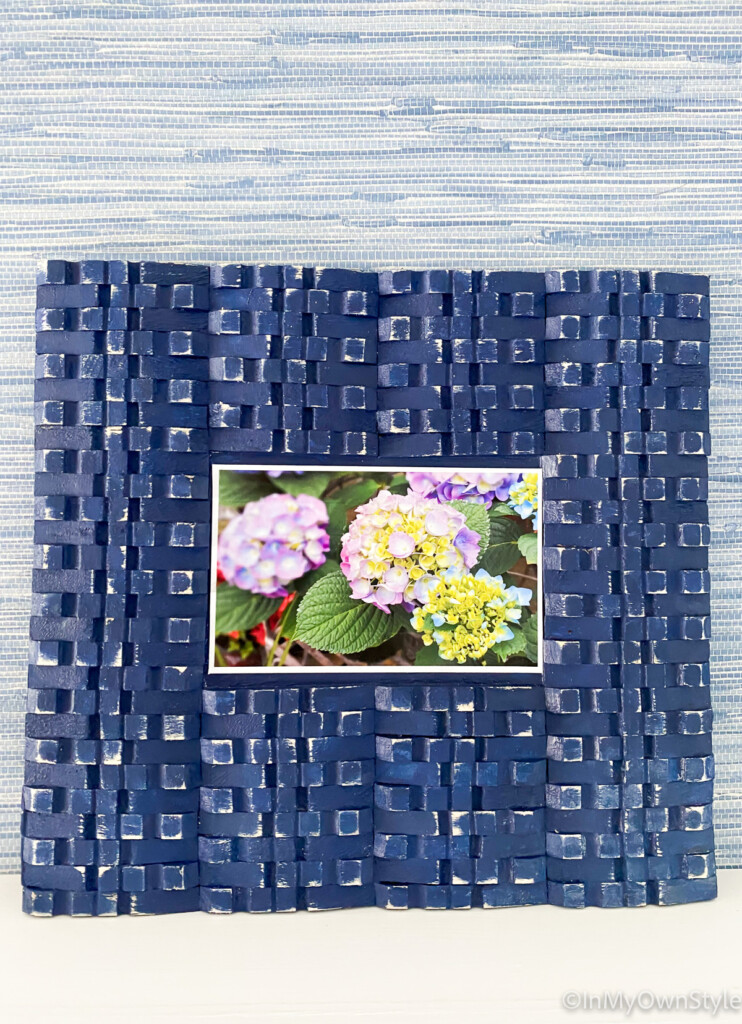 DIY picture frame with clothespins leaning on a ledge.